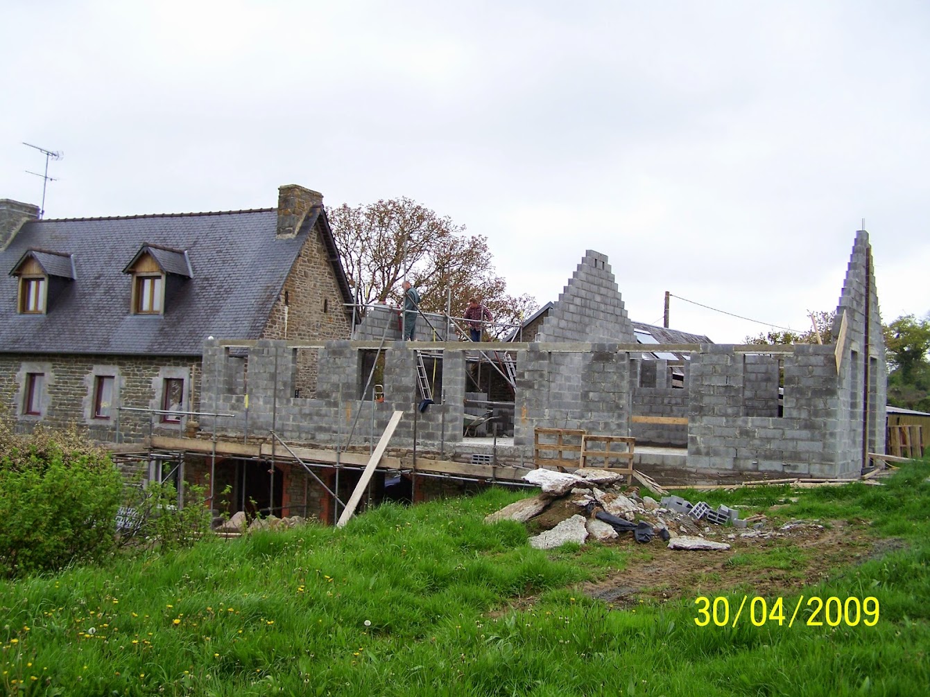 Stone-faced walls of the new apartment rising between the older buildings in April 2009